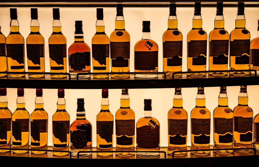single malt whisky bottles lineup, scotch whisky tasting glass amber