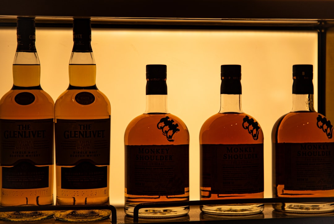 single malt whisky bottles lineup, amber whisky glass scotch